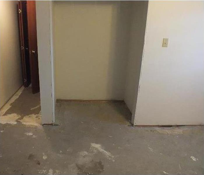 Concrete flooring with doors missing to a closet 