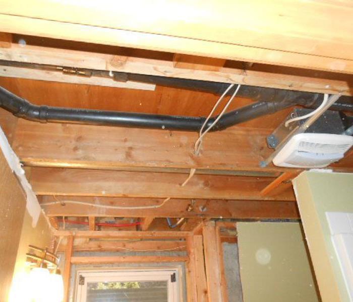 Drywalling missing from a ceiling with exposed wood beams 