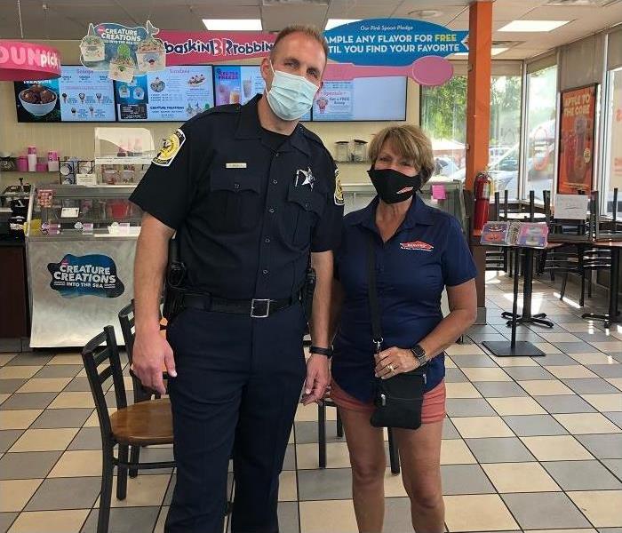 Police officer and woman posing inside of Baskin Robbins