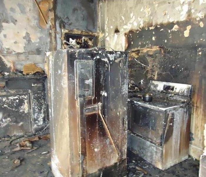 A kitchen with fire damage and soot
