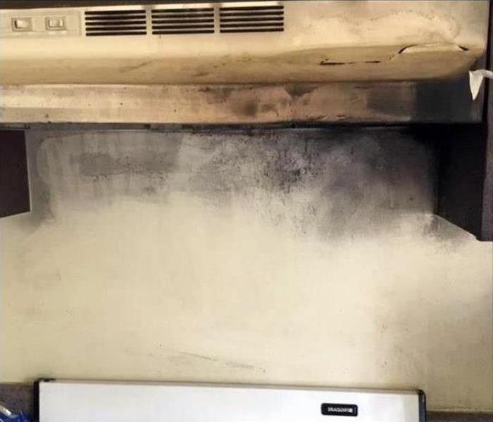 Fire and soot damage under a kitchen stove hood