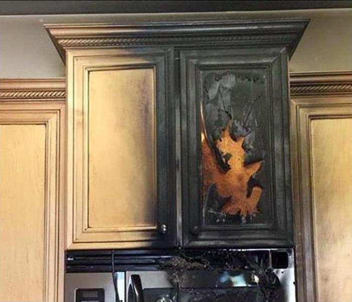 A kitchen cabinet with fire damage 