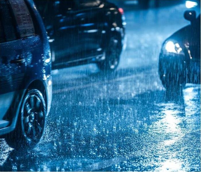 cars driving on street in heavy rain