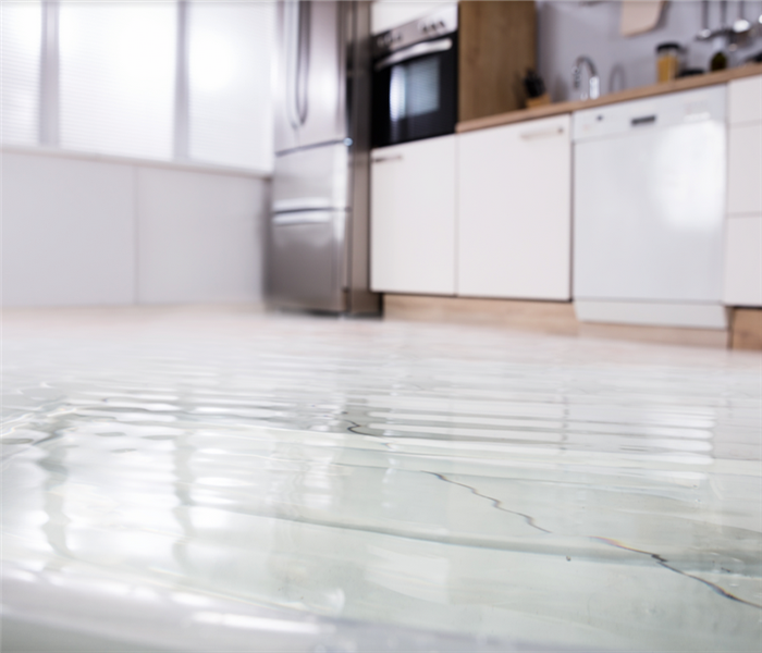 a flooded kitchen with water covering the tile floors